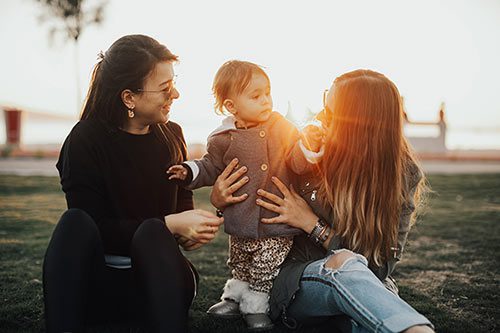 Birth mother visiting child and adoptive mother in park through open adoption at Lifetime Adoption.
