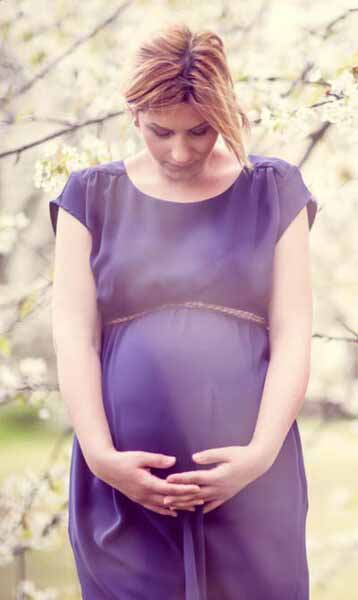 Pregnant and waiting birth mother with blossoms in background